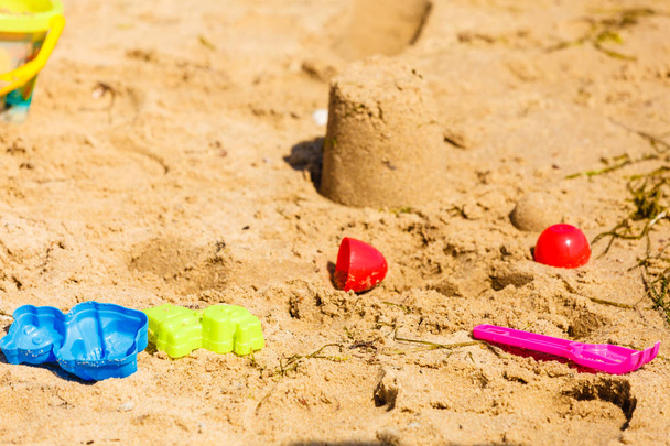 Summer kids toys on sandy beach druing summertime. Fun accessories objects concept. - Photo, image