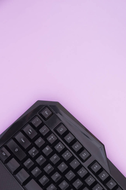 Keyboard, on a pink background, top view. Computer device, top view. Workspace flat lay - Photo, Image