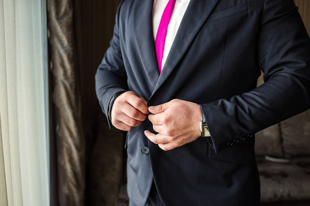Üzletember zakót visel, férfi kéz közelkép, vőlegény készül a reggeli esküvő előtt - Fotó, kép