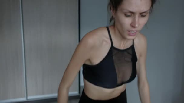 Atraktivní dívka doma běží na běžeckém pásu - Záběry, video