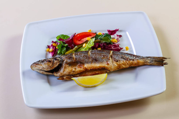 Grilled seabass with lemon and salad mix - 写真・画像