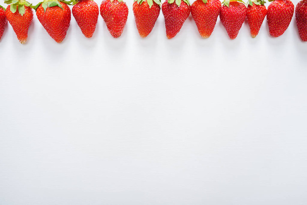 φράουλα φρούτα σε μια γραμμή σε λευκό ξύλο πίνακας φόντο. - Φωτογραφία, εικόνα