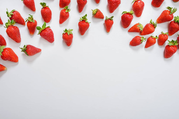 strawberry fruits on the right side on wooden background with copy space. View from above. - Photo, Image