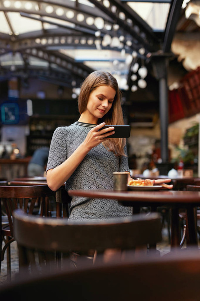 Woman In Cafe Taking Food Photo On Mobile Phone - Фото, зображення