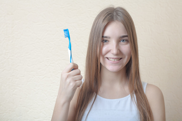 Portrait Of A Blond Woman Brushing Her Teeth - 写真・画像