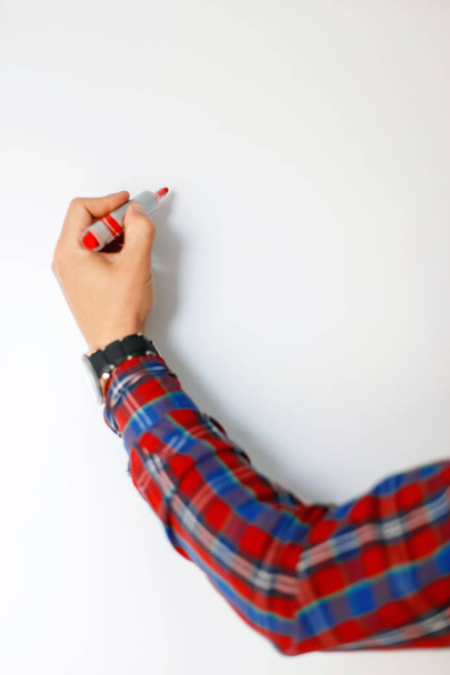 männliche Hand mit rotem Marker schreibt auf eine weiße Tafel - Foto, Bild