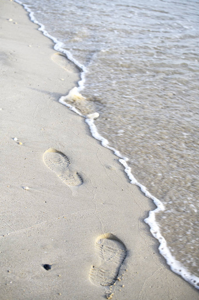 Footprints walking on the beach by the morning - Foto, imagen