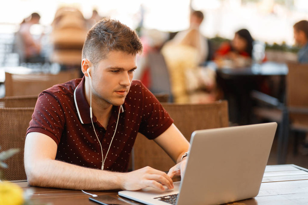 Przystojny mężczyzna blogger działa na laptopie w kawiarni - Zdjęcie, obraz