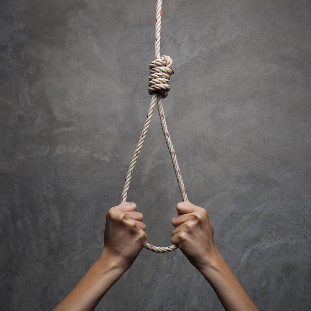 Hands holding rope slipknot in concept suicide - Foto, afbeelding