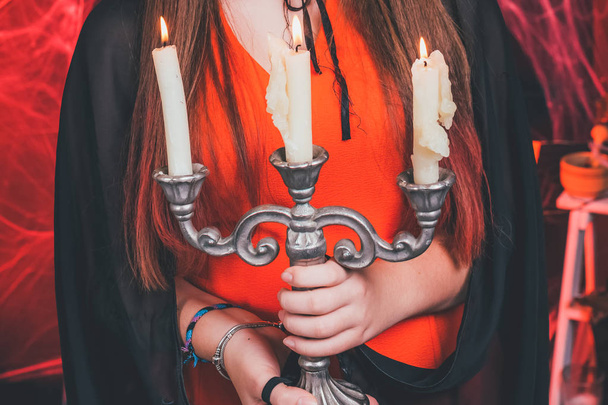 Хэллоуинская ведьма с тыквами и волшебными огнями в комнате. Ведьмак сцена арт-дизайна Хэллоуин партии арт-дизайн. свечи в руках. Закрыть
 - Фото, изображение