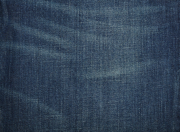 Dark indigo blue washed cotton jeans denim texture background with worn stains, close up - Foto, imagen