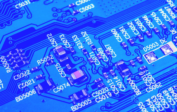 Macro shot of a Circuitboard with resistors microchips and electronic components. Computer hardware technology. Integrated communication processor in blue tones. Semiconductor. PCB. Closeup - Foto, immagini