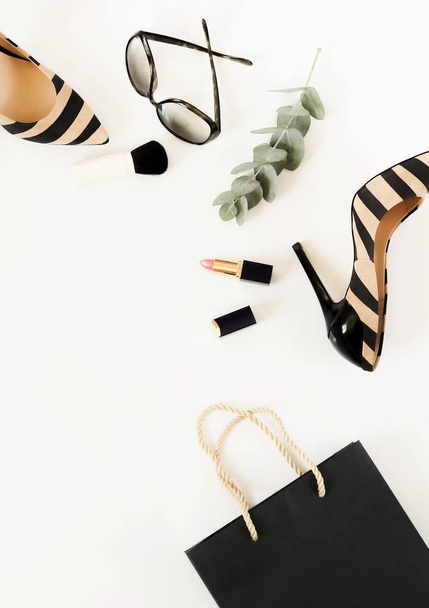Flat lay, top view of female fashion accessories.Beige handbag, sunglasses, high heel shoes and cosmetics on white background. Copy space - Foto, imagen