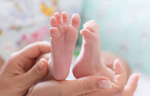 dětské nohy v ruce matky - Fotografie, Obrázek
