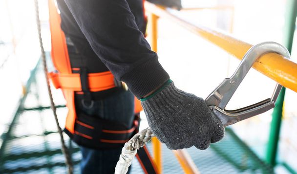 Travailleur de la construction portant harnais de sécurité et ligne de sécurité travaillant sur la construction
 - Photo, image