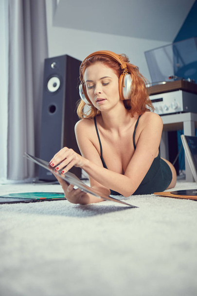 Young redhead woman listening to vinyl at home - Zdjęcie, obraz