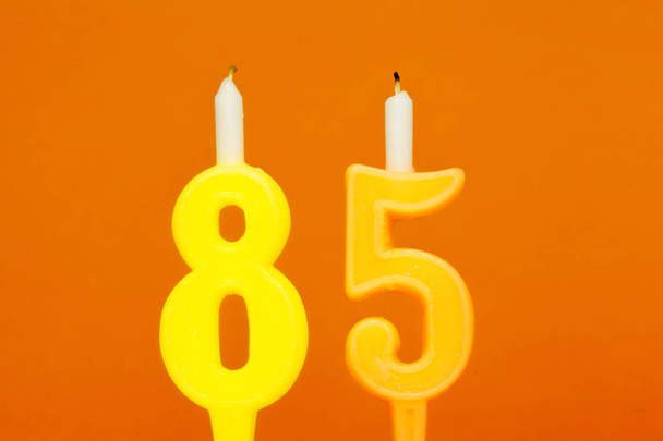 Colorful wax birthday candle  on orange background - Zdjęcie, obraz