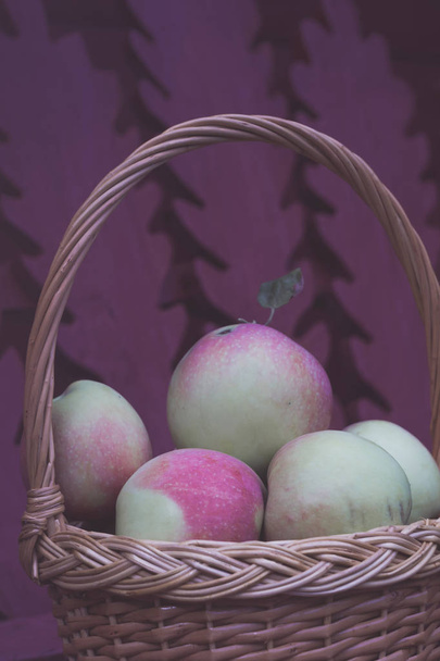Verse lekkere appels in een houten mand in de tuin. - Foto, afbeelding