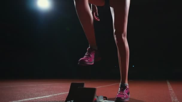 Spaanse atlete opleiding op de atletiekbaan in het donker. Slow motion - Video