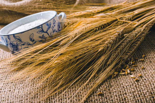 Wheat ears on brown sackcloth  - Fotoğraf, Görsel