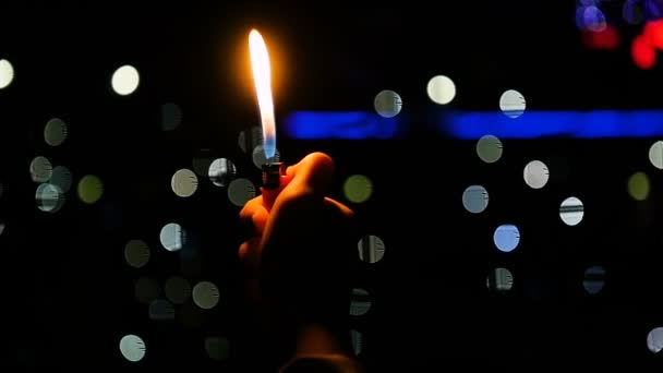 Closeup vysoký plamen zapalovače v sportovní fanoušek ruce na večerní hra - Záběry, video