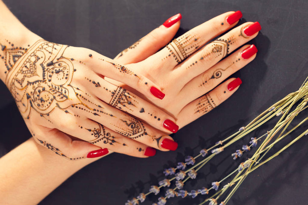 Red manicured hands with Mehndi  - 写真・画像