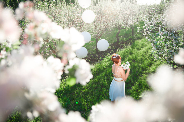 Widok z góry z młoda dziewczyna w kwitnący apple ogród, białe kwiaty wokół niej - Zdjęcie, obraz