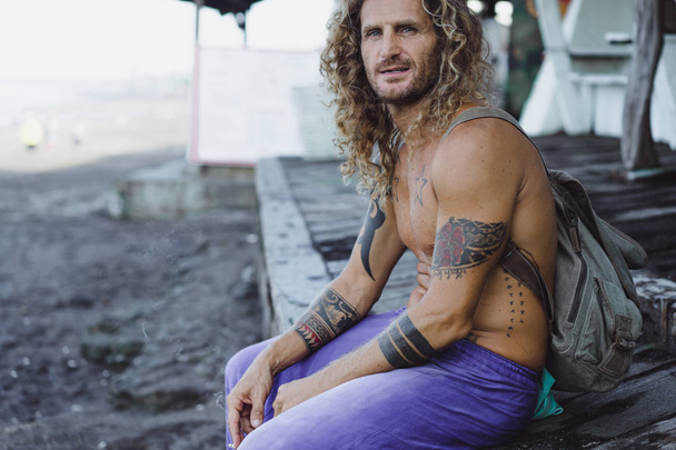 Handsome middle age man with long blond hair and tattoos - 写真・画像