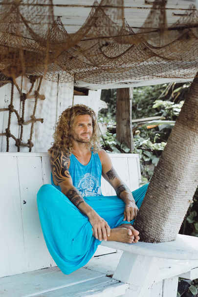 Handsome middle age man with long blond hair and tattoos - Photo, Image