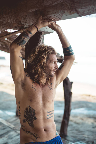 Handsome middle age man with long blond hair and tattoos - Foto, afbeelding