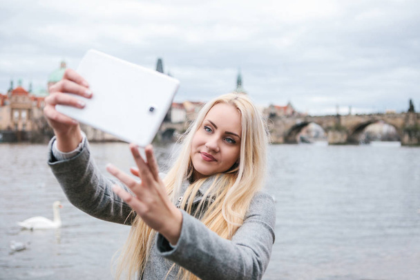 A beautiful young blond woman or tourist doing selfie. - Photo, Image