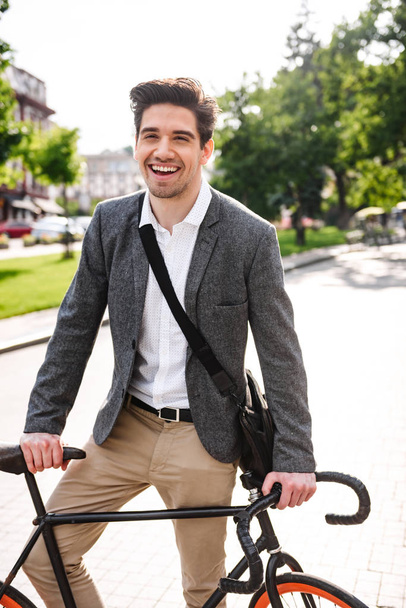 Felice giovane uomo d'affari in piedi con una bicicletta in strada della città
 - Foto, immagini