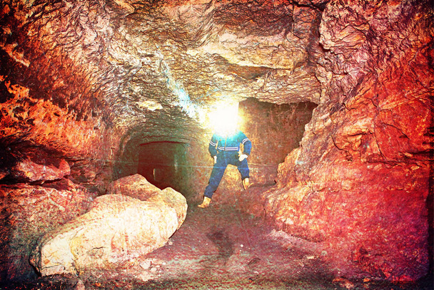 Un operaio controlla qualcosa nel tunnel minato abbandonato. Lavoro sotterraneo. Filtro hipster
.  - Foto, immagini