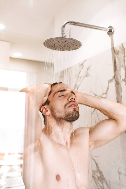 Sexy young naked man having a shower - Fotó, kép