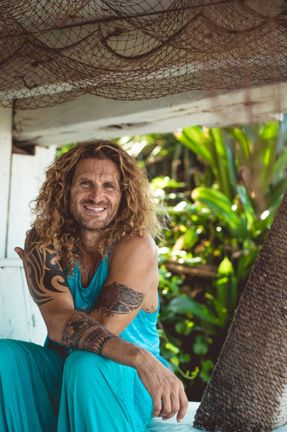 Handsome middle age man with long blond hair and tattoos - Фото, зображення