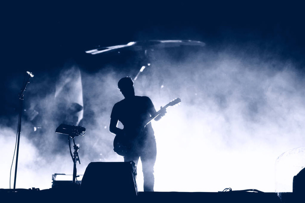 Silhouette de guitariste sur scène jouant de la musique live
 - Photo, image