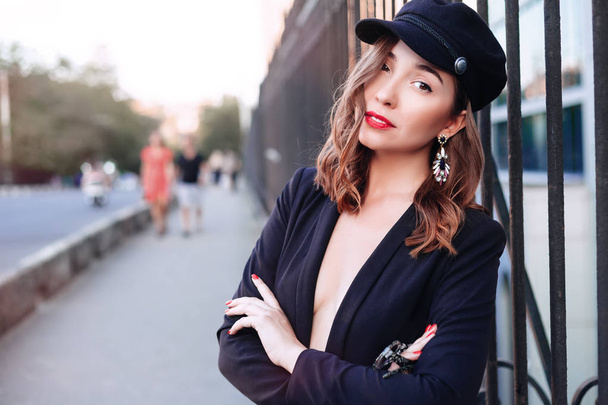 Outdoor portrait of a young beautiful fashionable woman wearing stylish accessories.Wearing hat and jacket. Female fashion, beauty and advertisement concept. Close up. Copy space for text. - Foto, imagen