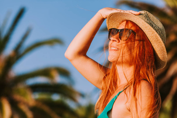 Молодая женщина наслаждается видом на пальмы
 - Фото, изображение