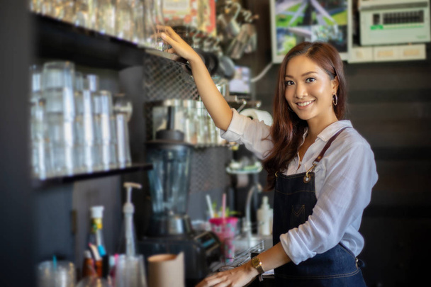 Kahve tezgahında gülümseyen ve kahve makinesi kullanan Asyalı kadın - çalışan kadın küçük işletme sahibi yiyecek ve içecek konsepti - Fotoğraf, Görsel