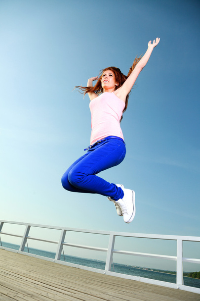 Chica atractiva Mujer joven saltando cielo
 - Foto, imagen