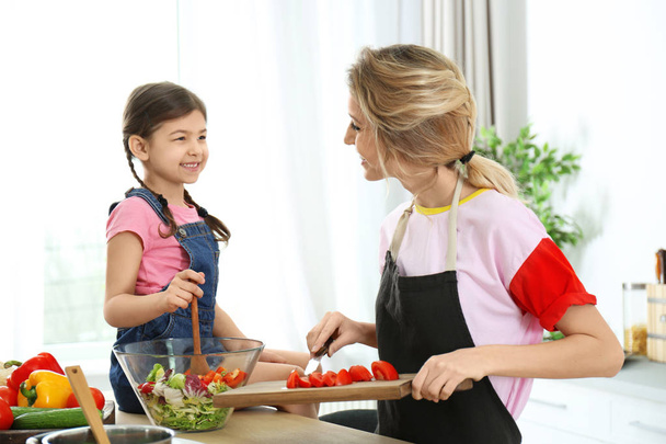 Młoda niania z uroczą dziewczynkę, wspólne gotowanie w kuchni - Zdjęcie, obraz