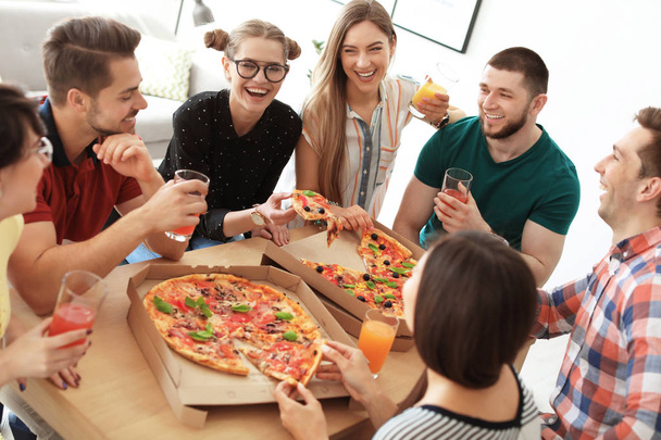 Young people having fun party with delicious pizza indoors - Foto, Imagen