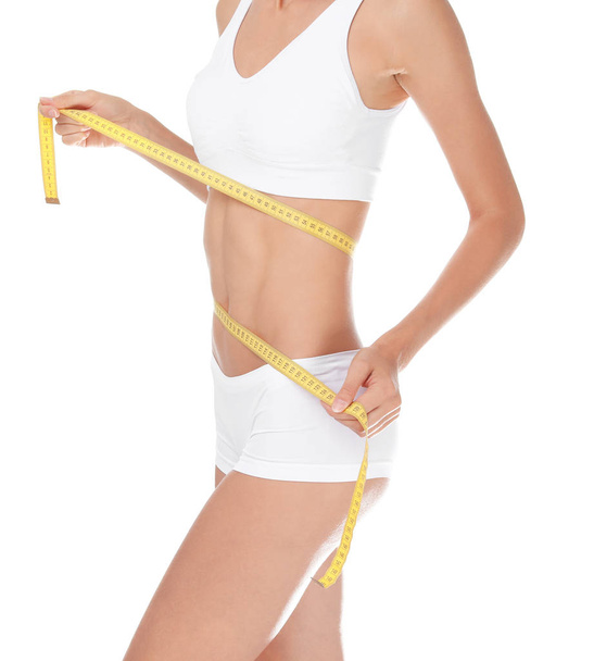 Young slim woman in underwear with measuring tape on white background. Weight loss diet - Fotó, kép