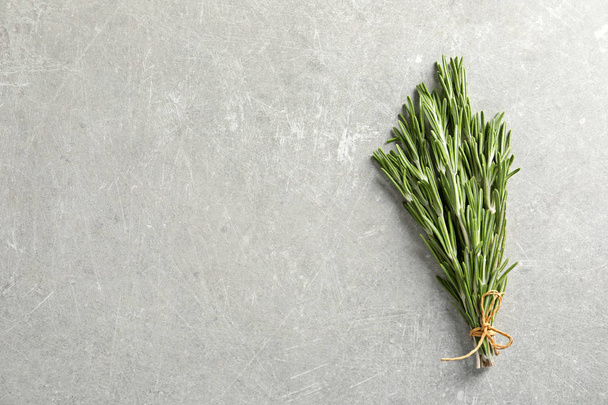 Fresh rosemary twigs tied with twine on gray table, top view - Fotografie, Obrázek