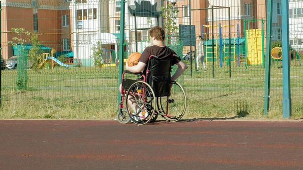 Homme handicapé joue au basket de son fauteuil roulant, En plein air
 - Photo, image