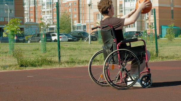 Engelli adam açık havada onun tekerlekli sandalye, basketbol oynuyor - Fotoğraf, Görsel
