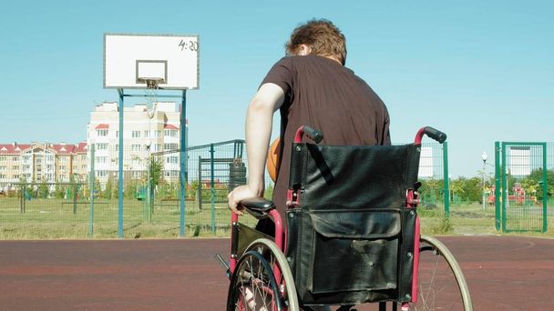 Homme handicapé joue au basket-ball de son fauteuil roulant, En plein air, Faire un effort en jouant
 - Photo, image