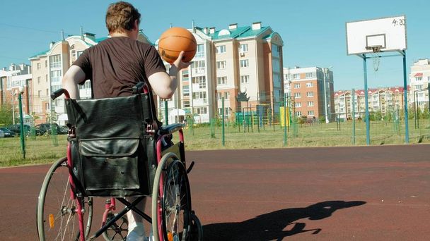 Tekerlekli sandalyeden, açık hava üzerinde Engelli adam çalış basketbol oynarken bir çaba yapmak - Fotoğraf, Görsel
