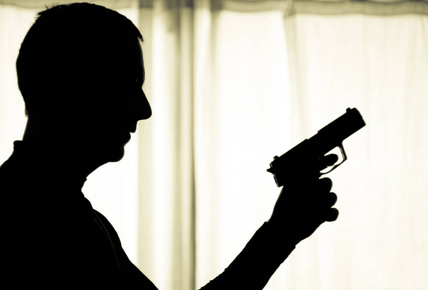 Mann in Alarmbereitschaft mit Waffe in der Hand - Foto, Bild