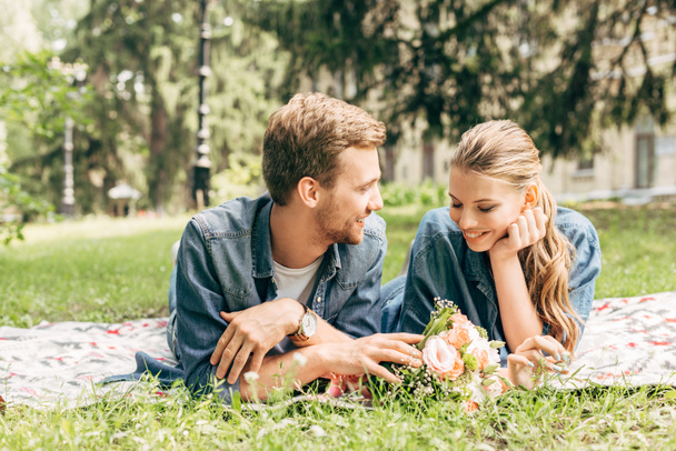 heureux jeune couple couché sur l'herbe au parc et flirter
 - Photo, image